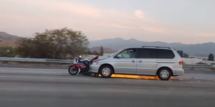 Here'a a crazy highway accident of a motorcycle getting stuck on a minivan.