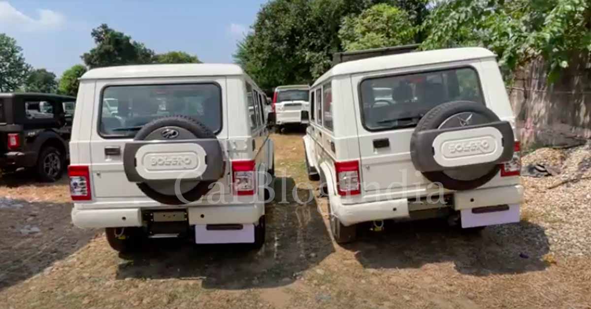 rear of the mahindra bolero with new logo parked alongside old model