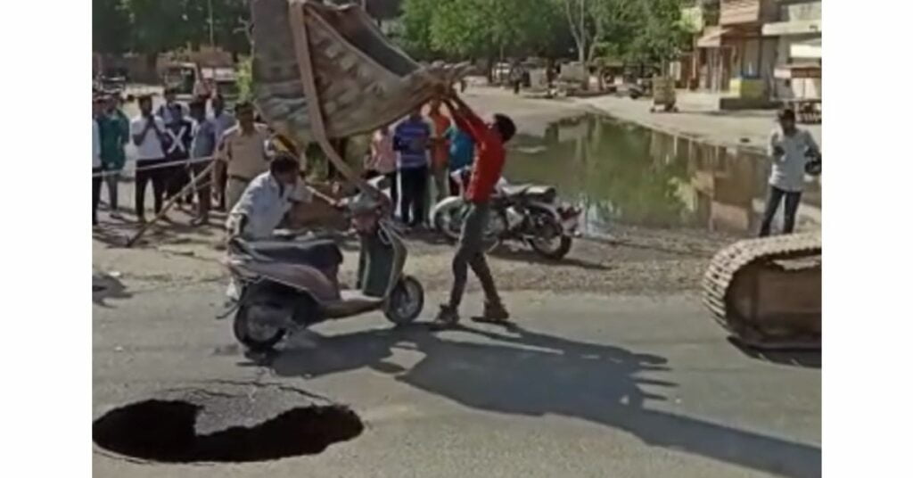 Scooty Stuck in hole on the road