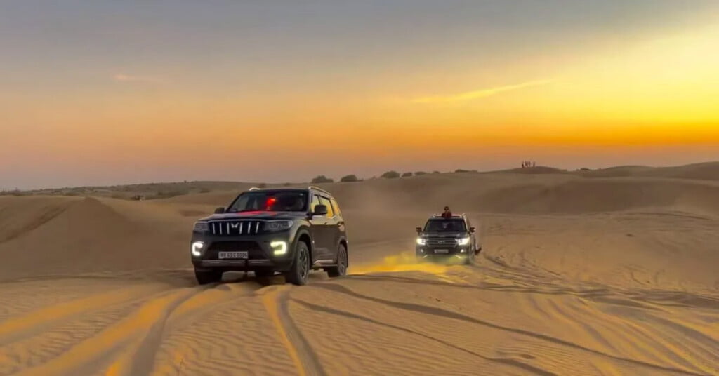 Mahindra Scorpio N driving through desert along with a Toyota Land Cruiser