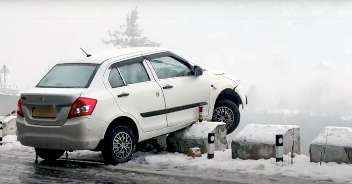 Maruti Dzire Hanging Over Parapet on Road in Snow